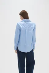 Camisa de algodón blanca, de corte entallado al cuerpo, con cuello camisero, manga larga y cierre frontal de botones.