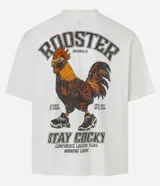 Remera color crudo de corte boxy, con cuello redondo y mangas cortas. Estampado trasero con un gallo con gafas y zapatillas, la palabra 'Rooster' y la frase 'Stay Cocky'.
