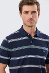 Remera polo de manga corta con diseño a rayas horizontales en tonos azules, celestes, verdes y beiges sobre base azul marino. Presenta cuello camisero con cierre frontal de botones y un pequeño logo bordado en el pecho.