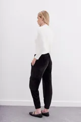 Pantalon tipo babucha confeccionado en terciopelo, con cintura elástica, puños ajustados en la botamanga, bolsillos frontales tipo plaqué con remaches metálicos y bolsillos cargo laterales.