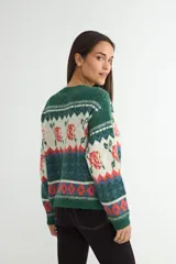 Cardigan de punto con diseño jacquard multicolor, cuello redondo y cierre frontal con botones. Presenta un patrón geométrico y floral en tonos verde, rojo, azul y crema.