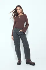 Top de punto acanalado color marrón, de manga larga y calce ajustado al cuerpo. Presenta escote redondo y detalle de botones en los puños.