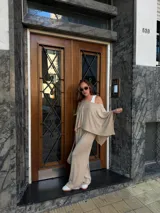 Pantalón de lanilla color beige, de corte recto y tiro alto, con diseño holgado y fluido.