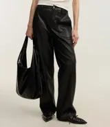 Pantalón negro de cuero sintético, corte recto, con bolsillos delanteros grandes y cierre con botón y cremallera.