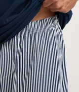 Pijama corto masculino de algodón, compuesto por una remera azul marino con estampado de Bob Esponja y un short a rayas blancas y grises con cintura elástica.