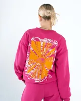 Buzo fucsia de cuello redondo y corte oversized, confeccionado en algodón rústico con estampa serigráfica de un ojo con rayos sobre un fondo de remolinos.