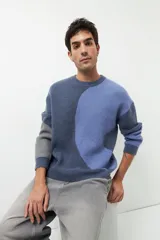 Sweater de punto con diseño geométrico en tres tonos de azul y gris, de cuello redondo y manga larga.