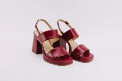 Sandalias de plataforma color crema, con tiras anchas de charol y hebilla ajustable en el tobillo.