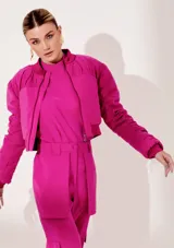 Campera bomber fucsia de cupro con forro y acabados acolchados. Tiene largo corto, cuello, puños y bajo rectos, mangas con detalles acolchados y pliegues, y cierre frontal con cremallera metálica.