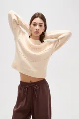 Sweater de punto color azul con diseño de fantasía en forma de líneas curvas punteadas en color celeste. Presenta cuello redondo a la base, mangas largas con puños acanalados y corte holgado.