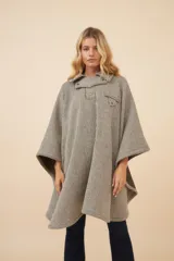 Poncho de lana fina con diseño de rayas diagonales, cuello camisero, cartera con botones a presión y bolsillo ojal en el pecho.