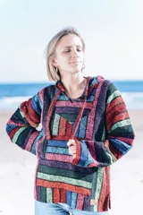 Buzo con capucha y bolsillo tipo canguro, con diseño a rayas horizontales de colores vibrantes.