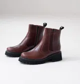 Botas Kiev de cuero vacuno color marrón, con suela de goma negra tipo track. Tienen cierre YKK en el lado interno y elástico en el lado externo. La punta es redonda y ancha.