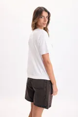 Camiseta blanca de manga corta con estampado azul en el pecho que dice 'Saint Tropez Sailing Club France'.