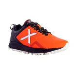 Championes deportivos Munich modelo Stroke 04, diseñados para hockey, con combinación de colores naranja y negro. Presentan el logo característico de la marca en blanco en el lateral, suela con relieve para mayor tracción y cordones negros.