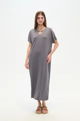 Vestido midi de corte holgado, color negro, con mangas cortas, cuello en V y detalle de cuentas decorativas en el escote.