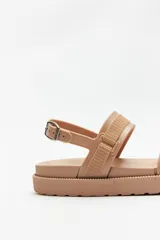 Sandalia estilo chunky color rosa metálico/cobre, con plataforma de goma texturizada. Posee dos tiras anchas ajustables con hebillas, una en el empeine y otra sobre los dedos, y una tira de tobillo con hebilla metálica.