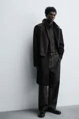Abrigo regular fit de color negro, confeccionado con mezcla de lana y cashmere. Presenta cuello con solapas de muesca, manga larga, bolsillos de vivo en la cadera, abertura central en la espalda y cierre frontal de botonadura con tres botones.