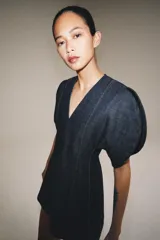 Vestido corto de denim con escote en pico, mangas cortas abullonadas con aberturas y costuras con pespuntes a contraste. Cierre posterior con cremallera.