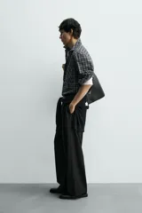 Camisa de corte relajado confeccionada en voile de algodón, con estampado de cuadros. Presenta cuello solapa, manga larga con puños abotonados, bolsillo de parche en el pecho y cierre frontal de botones.
