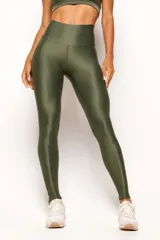 Calza deportiva de tiro alto en color verde militar, confeccionada en tejido técnico con acabado satinado. Presenta un diseño anatómico que se ajusta al cuerpo y cuenta con un bolsillo interno.