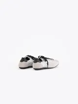 Zapatillas de estilo urbano confeccionadas en nylon plateado con detalles de cuero vacuno descarne en gris y negro. Cuentan con cordones negros y suela de goma.