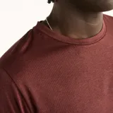 Remera deportiva New Balance de manga corta y cuello redondo, en color bordó con tecnología de secado rápido y logo reflectante en el pecho.