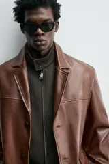 Blazer de corte relajado confeccionada en piel napada, con cuello de solapas de muesca, manga larga y cierre frontal de tres botones. Presenta bolsillos con solapa en la parte delantera.