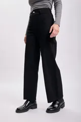 Pantalon de jean negro de corte ancho y tiro alto, con cierre frontal y bolsillos. Presenta un acabado deshilachado en el ruedo.