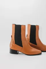 Botas de cuero color beige con elásticos laterales negros, taco cuadrado y punta cuadrada.