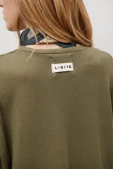 Sweater de tejido de punto color beige, con escote en V y mangas largas. Presenta un diseño básico y versátil de corte recto.