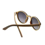 Lentes de sol Indie Hill con marco redondo de madera color nogal y lentes grises degradé.
