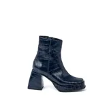 Botas cortas negras de cuero vacuno con textura tipo cocodrilo. Taco de madera forrado en cuero de 8cm, entre suela de goma de 2cm forrada en cuero, inclinación de horma de 6cm y caña de 15cm. Cierre YKK del lado interno y horma de punta cuadrada.