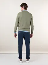 Pantalón chino azul marino de corte slim fit, confeccionado en gabardina con 77% algodón, 20% de algodón reciclado y 3% elastano. Presenta bolsillos delanteros y traseros. Tiene un lavado final con enzima ácida que le da un aspecto desgastado.
