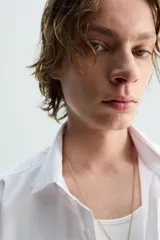 Camisa de corte slim fit con textura, cuello italiano y manga larga con puños abotonados. Presenta cierre frontal con botones.