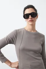 Remera de manga larga color blanco, de calce entallado, con cuello redondo a la base y costuras verticales decorativas que estilizan la silueta.