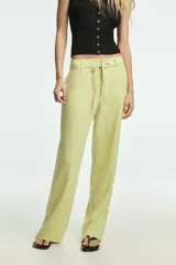 Pantalón de tiro medio confeccionado en mezcla de lino, con cintura ajustable mediante lazada, trabillas, bolsillos laterales y cierre frontal con cremallera y botón.