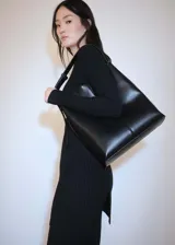 Vestido corto de punto acanalado, con cuello redondo y manga larga. Presenta un diseño ajustado en el torso que se abre ligeramente en la falda.