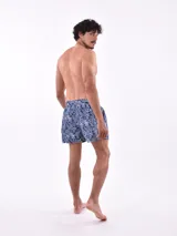 Short de baño blanco con estampado de hojas en tonos azules y rosados, cintura elástica con cordón ajustable.