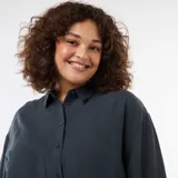 Blusa fluida de manga larga en color azul oscuro, con cuello camisero clásico y cierre frontal de botones a tono.