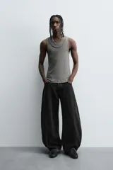 Camiseta sin mangas (tank top) negra, de corte slim fit, con cuello redondo de efecto doble.