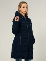 Campera puffer larga de Tommy Hilfiger en color azul marino. Presenta un diseño acolchado horizontal, cierre frontal completo con cremallera, capucha ajustable con cordones y dos bolsillos laterales con cierre. Incluye detalles distintivos de la marca.