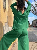 Pantalón tipo palazzo de tiro alto, confeccionado en jersey de algodón color verde. Presenta un diseño amplio con bolsillos laterales y una faja ancha en la cintura que proporciona ajuste y soporte.