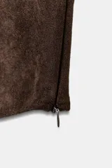 Top crop de escote recto y tirantes anchos, confeccionado en tejido con efecto ante. Presenta un diseño ajustado con cierre lateral mediante cremallera oculta.