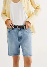 Bermuda de jean azul claro, tiro medio, corte recto y holgado, con largo por encima de la rodilla.