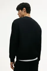 Buzo de cuello redondo con hombros caídos y puños y bajo acanalados. Confeccionado en tejido de mezcla de algodón con interior cepillado suave.