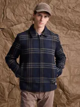 Chaqueta de lana con cierre frontal completo, diseño a cuadros en tonos azul marino y verde, cuello camisero y bolsillos laterales.