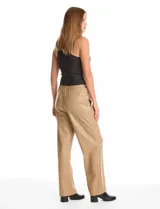Pantalón de eco cuero negro con pretina elastizada, bolsillos laterales y pierna recta con costura frontal decorativa.
