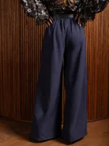 Pantalón palazzo de tiro alto en color azul, con pinzas frontales, bolsillos laterales y cintura elástica.