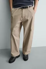 Pantalón cargo de corte relajado confeccionado en tejido de algodón con elasticidad. Presenta bolsillos laterales tipo cargo con solapa en las perneras, bolsillos frontales y bolsillos traseros de doble vivo. Cierre frontal con cremallera y botón.